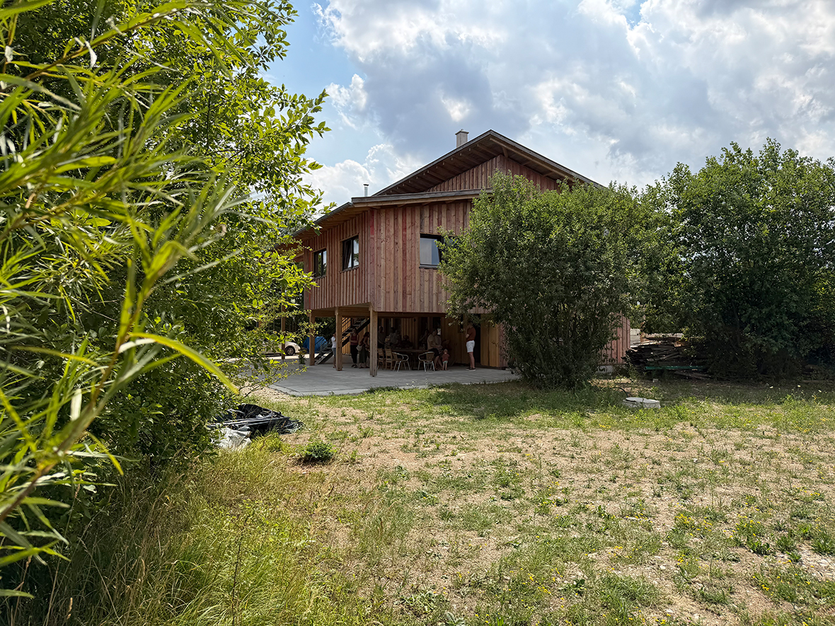 Ein Holzhaus inmitte von Bäumen und Büschen