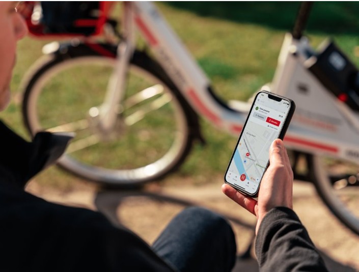 Vier Radfahrer radeln bei strahlendem Sonnenschein auf einem Radweg im Grünen